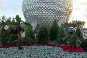 The entrance to Epcot during Christmas with Goofy and Donald dressed up